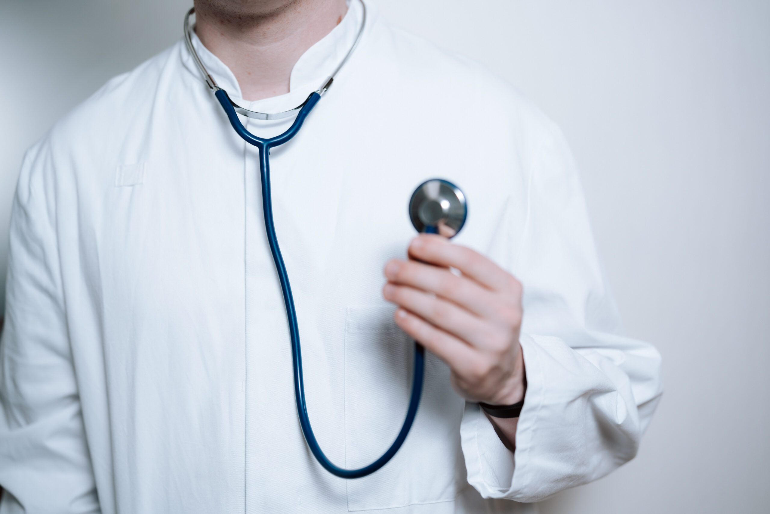 Close-up of doctor using stethoscope on patient's back during medical examination.